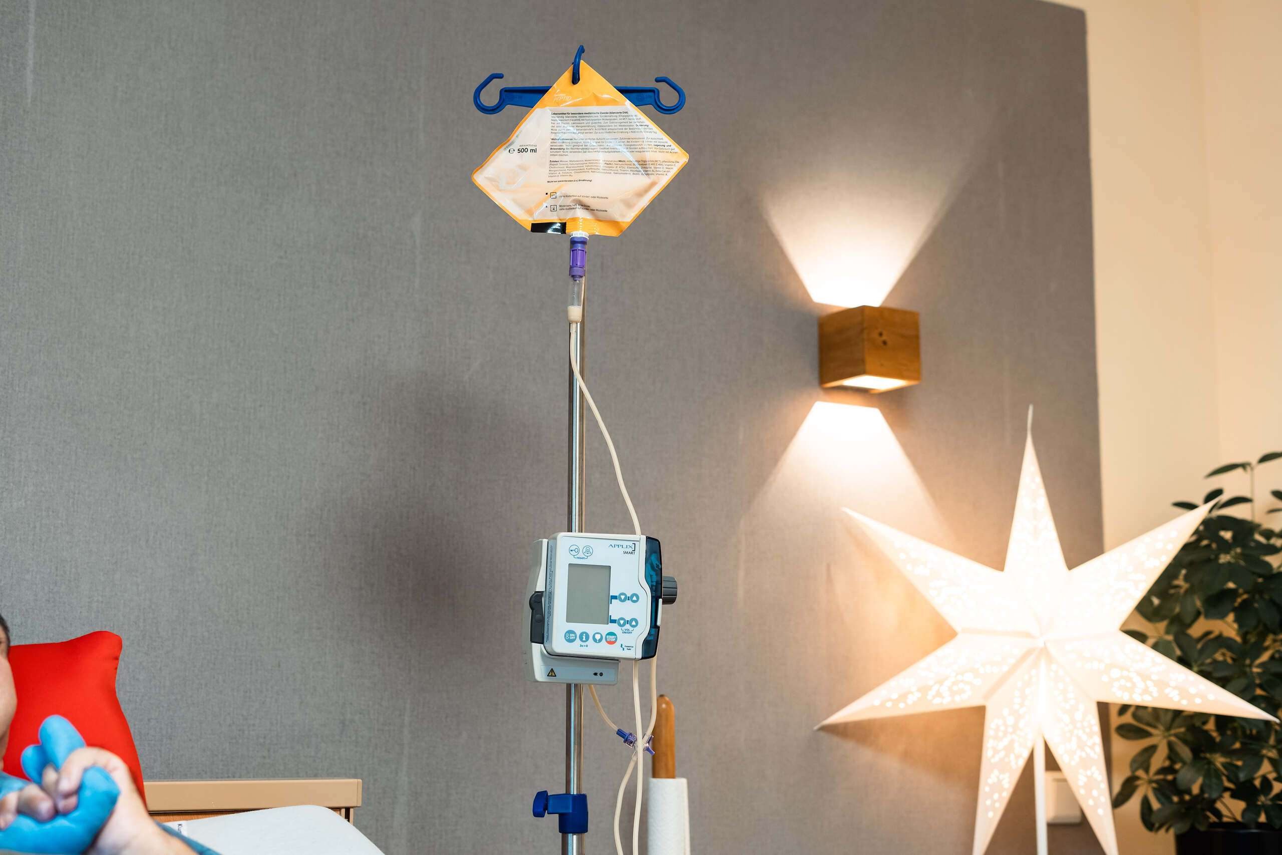 Infusionspumpe mit einem gelben Infusionsbeutel, montiert an einem Ständer im Krankenhaus.